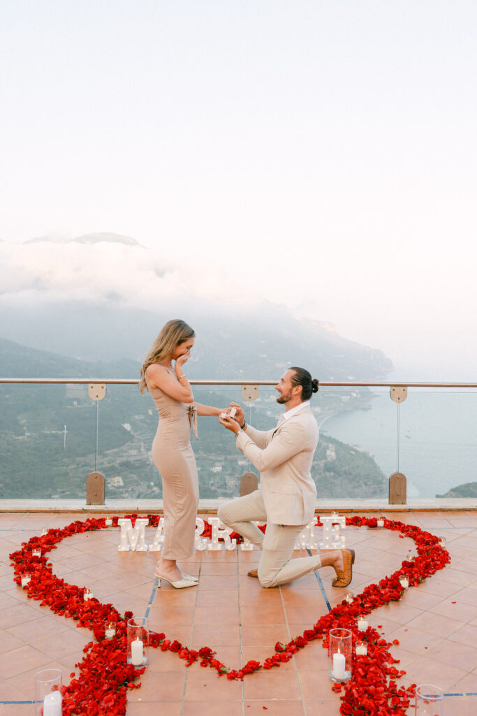luxury Ravello proposal setup with red rose petals on a private terrace and live pianist at sunset